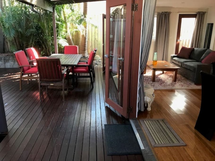 Indoor space opening onto private oasis deck in palm garden