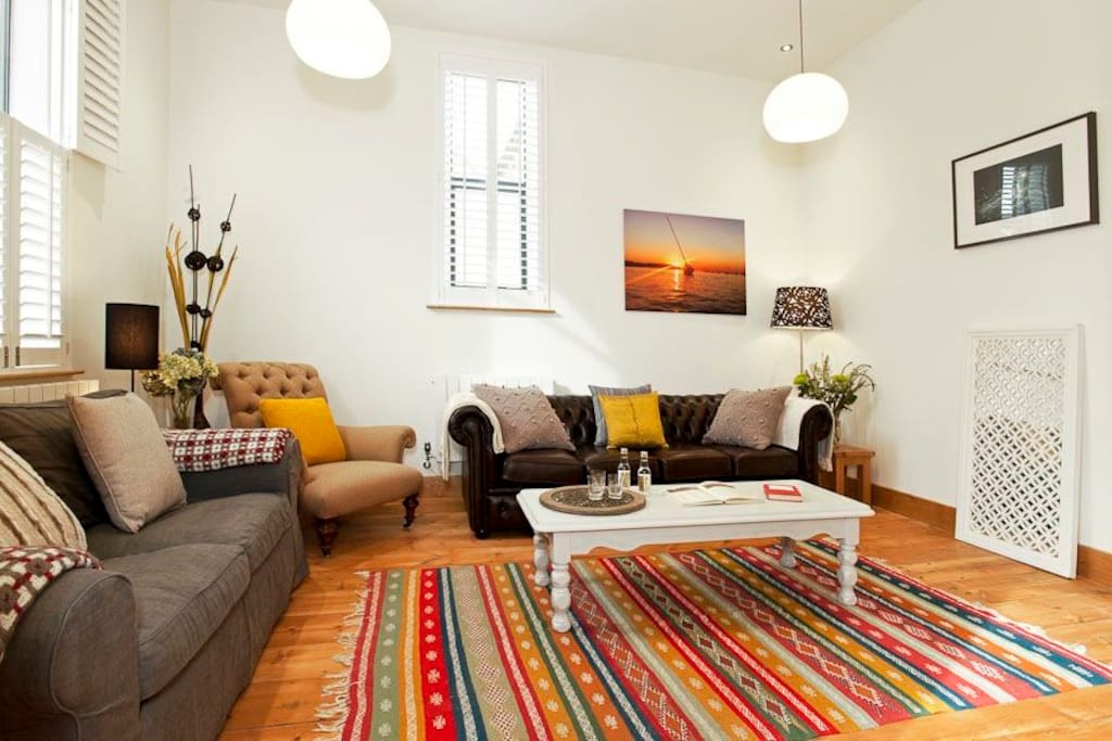 Living room with plantation shutters and original floorboards and lights.