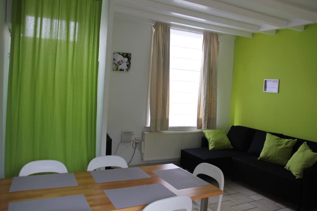 Bright living room with sofa bed, dining table and smart tv