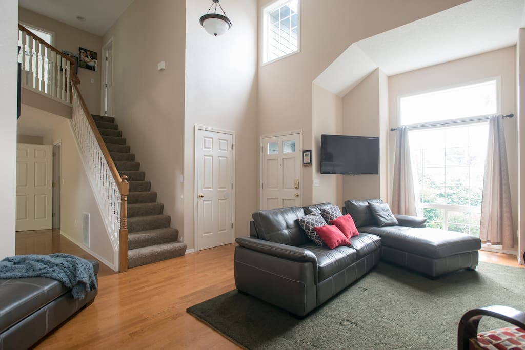 Living room area with TV and stairs to 3 bedrooms upstairs
