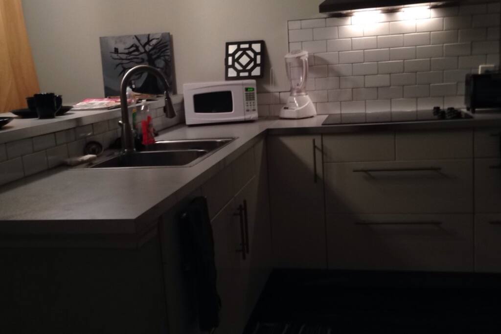 In the kitchen there is a double sink , microwave , blender, and small oven to make a delicious breakfast lunch or dinner.