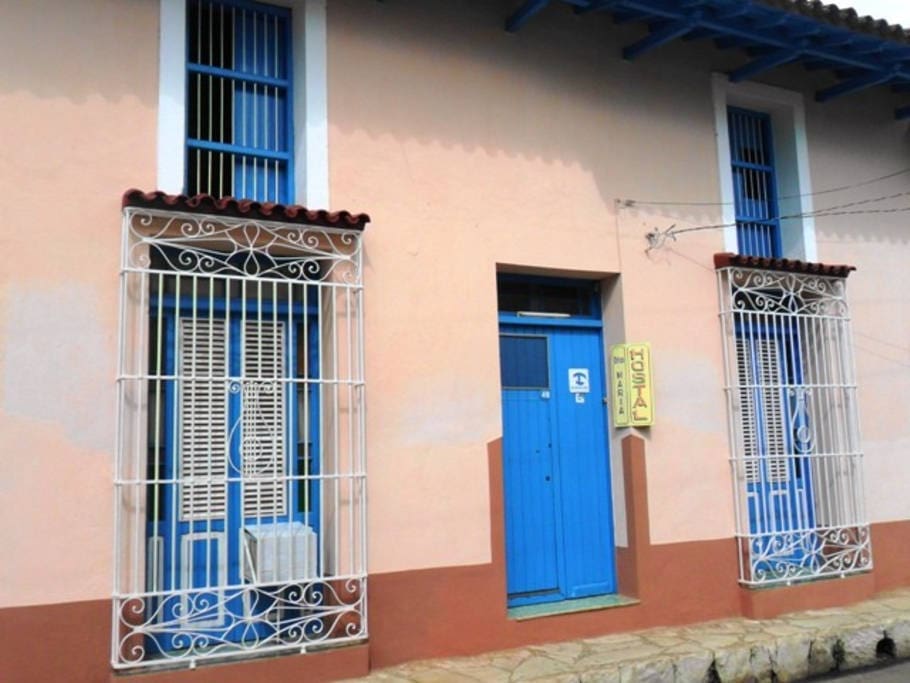 Fachada del Hostal. En él se aprecian las aceras de piedra y los grandes ventanales