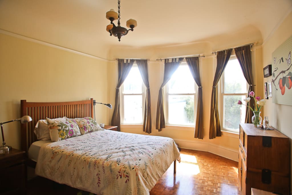 Spacious sunny master bedroom with queen bed