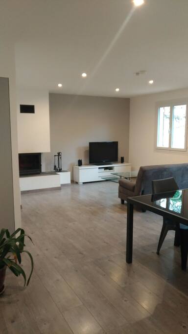 Grand salon lumineux avec coin télé et accès direct à la terrasse