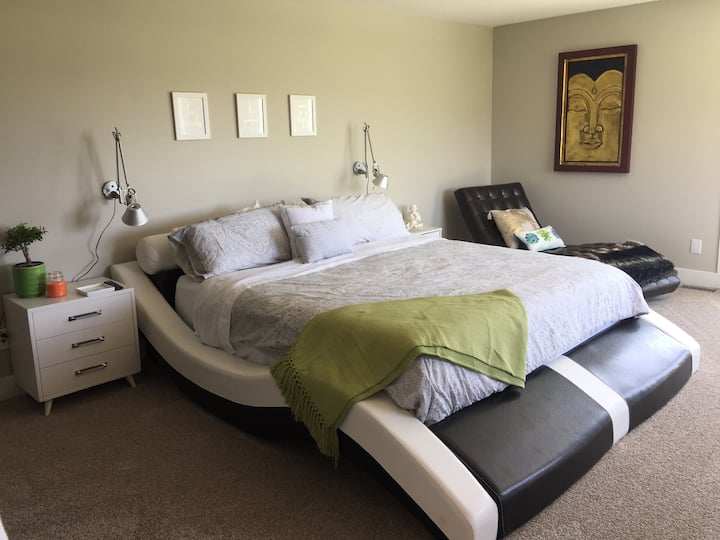 غرفة نوم بسرير بحجم كبير مع شرفة في الطابق الثاني وحمام داخلي