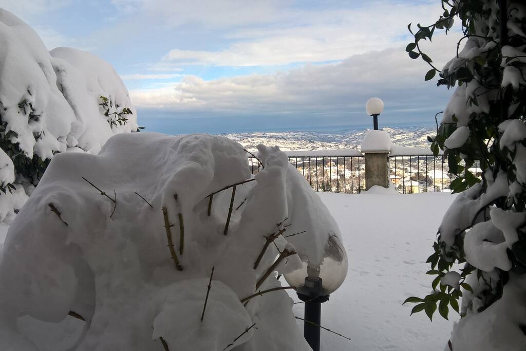 Neve in giardino e mare all'orizzonte