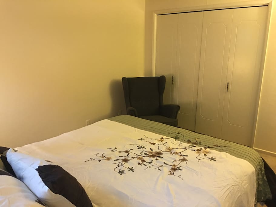 Another view of the bedroom, armchair, and closet.