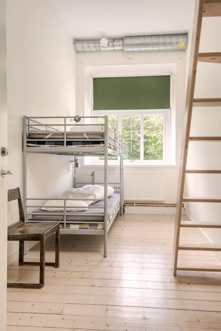 Room with a bunk bed and two beds on the loft.