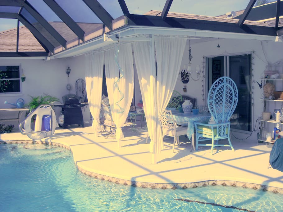 Lanai, pool, dining area, seating area with lounge chairs.