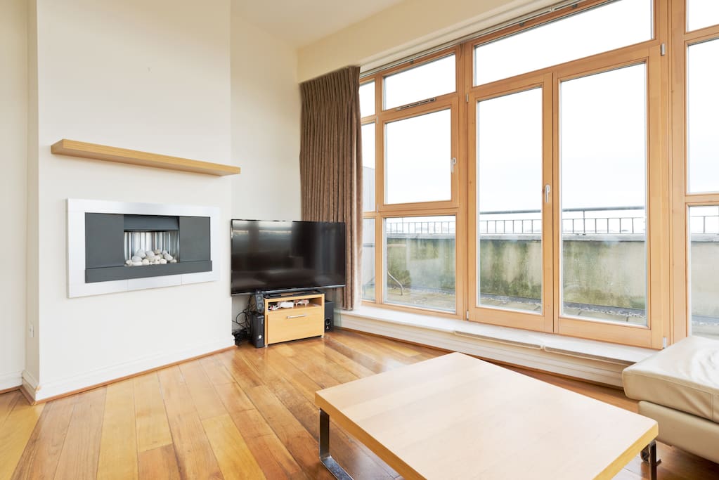 Big, bright living area with 52 inch TV and fireplace.