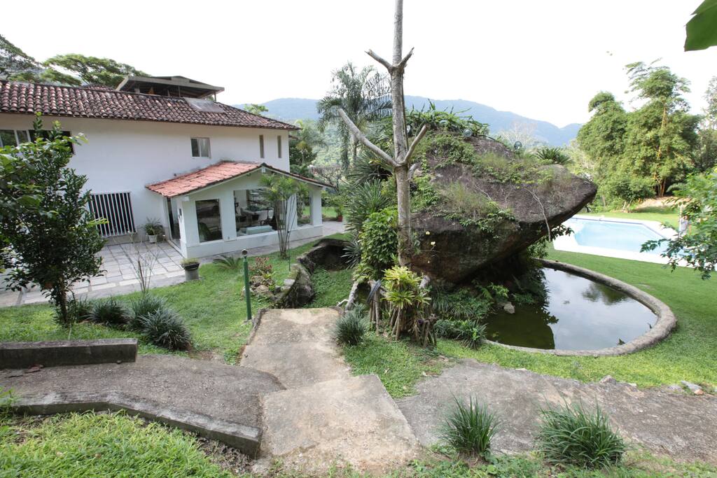 Fachada lateral da casa com o lago e piscina