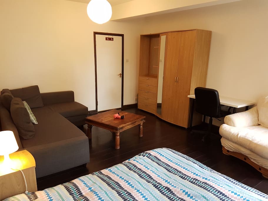 Your bedroom other side with large L-shape sofa, big coffee table, desk, comfy armchair and big wardrobe