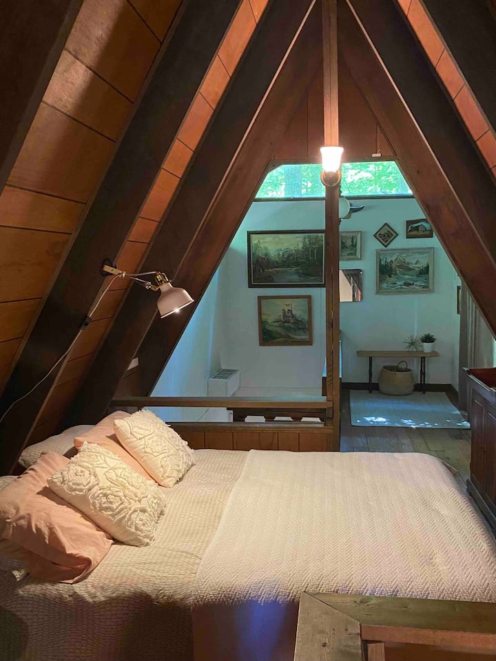 The upstairs queen bed, with a TV and two walk out decks.