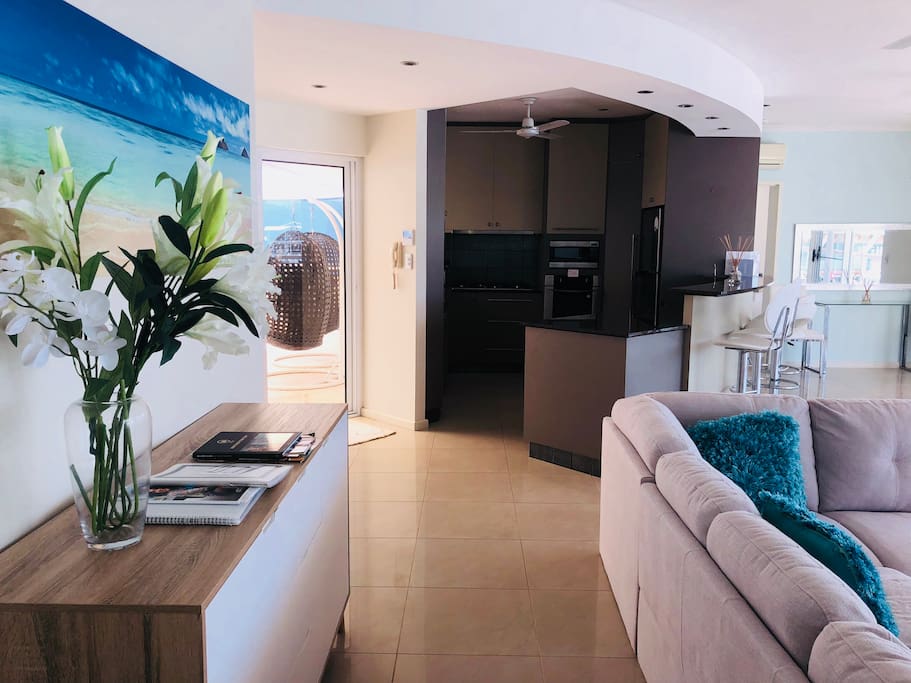 Lounge with buffet and kitchen area opens up to shaded patio area with spa bath