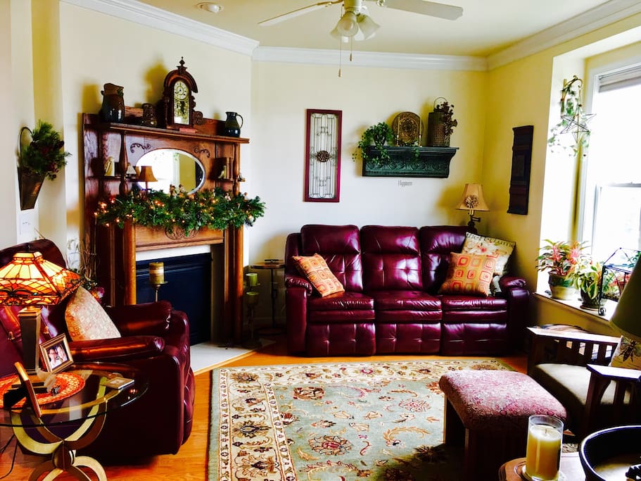 Reclining couch and chair, cozy fireplace with historic mantle and cable TV.