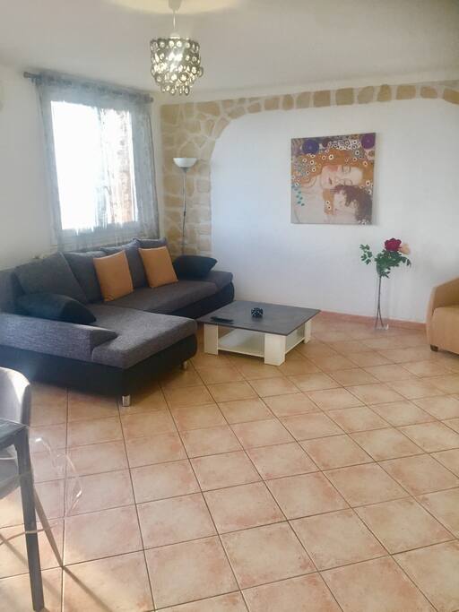 Grande pièce à vivre ensoleillée donnant sur le balcon équipée d'une table, tv, fauteuil, canapé convertible ce qui pourra faire deux couchage supplémentaire
