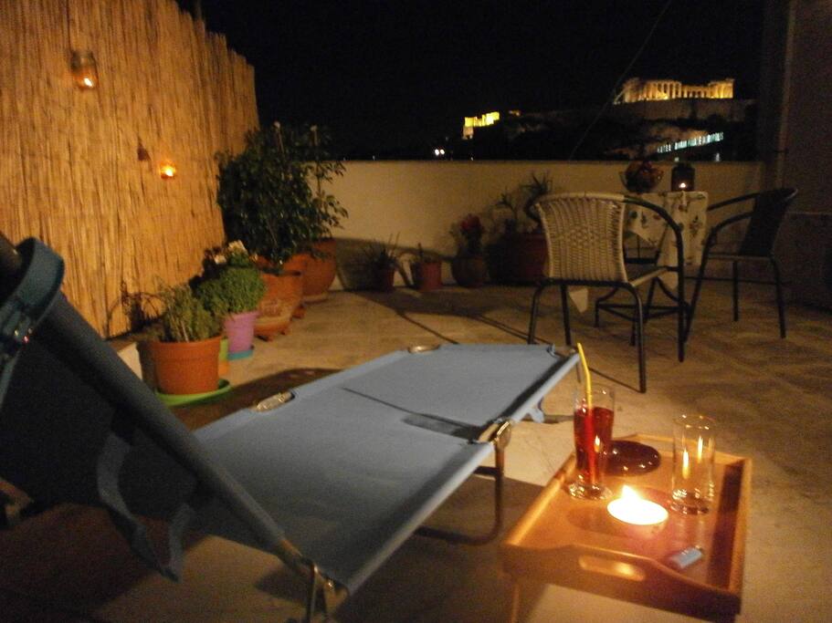 Night view of Acropolis from lounge chair on huge terrace.