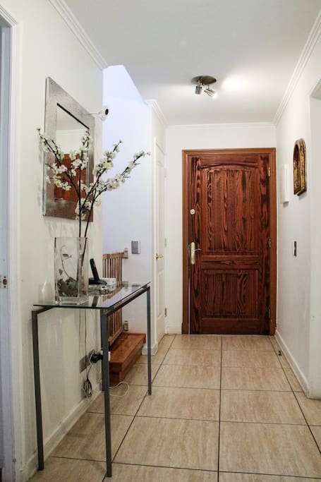 house entrance with staircase on the right hand side (with baby gate protection) and a hallway table