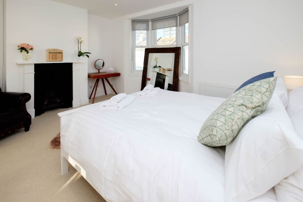 The master bedroom with a king size bed and a huge ensuite bathroom