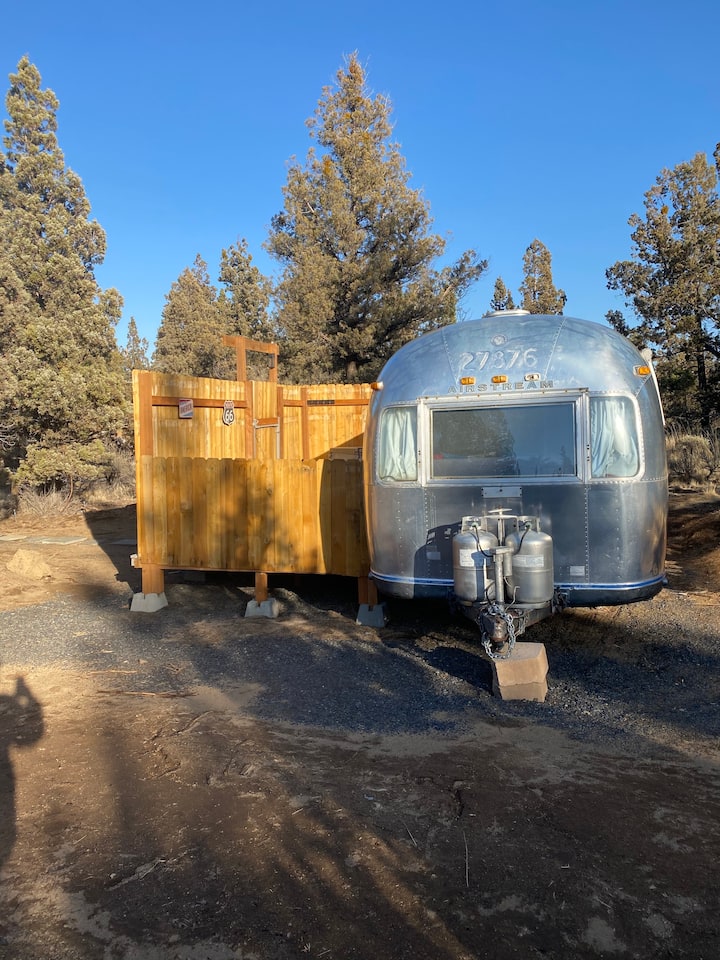 an old airstream with a fence