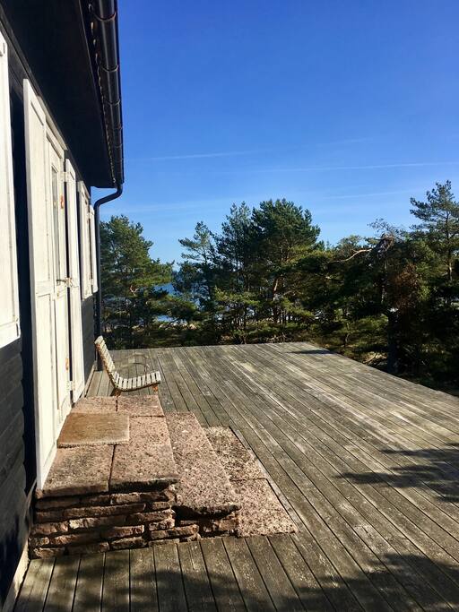 Stugan i renoveringsbehov med trädäck runt huset och utsikt över havet har långt till närmsta granne.