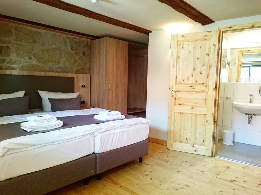Schlafzimmer mit Doppelbett und Bad