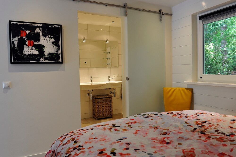 浴室配有马桶、步入式淋浴间和双水槽。卧室和浴室之间的滑动玻璃门。电动地暖