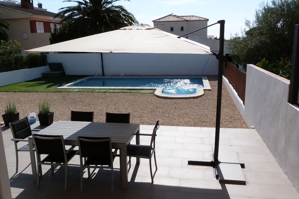Jardin amplio con piscina y cesped.
