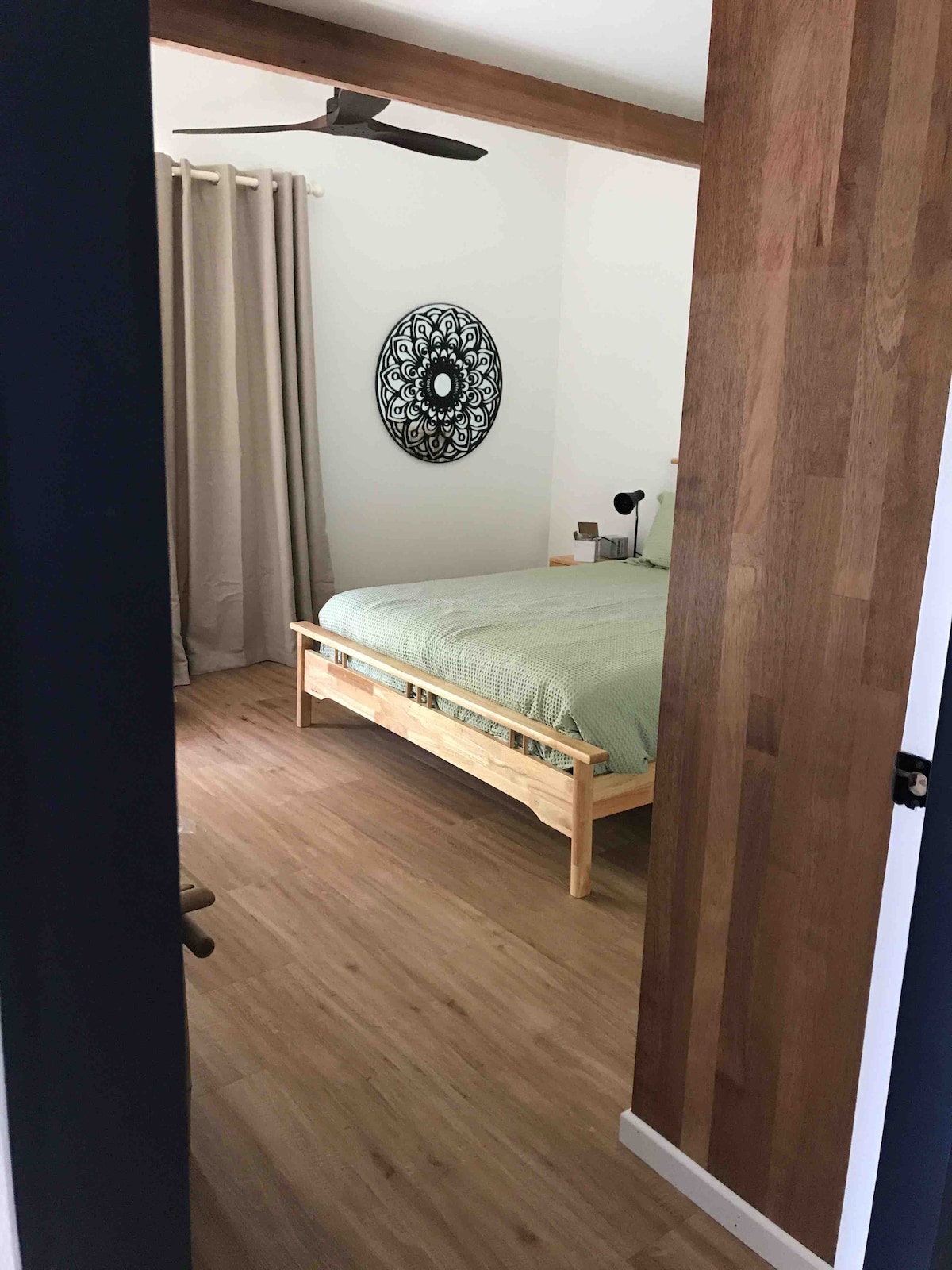 Spavaća soba u prizemlju s drvenim svodom i zrcalom od cvijeća Lotus.