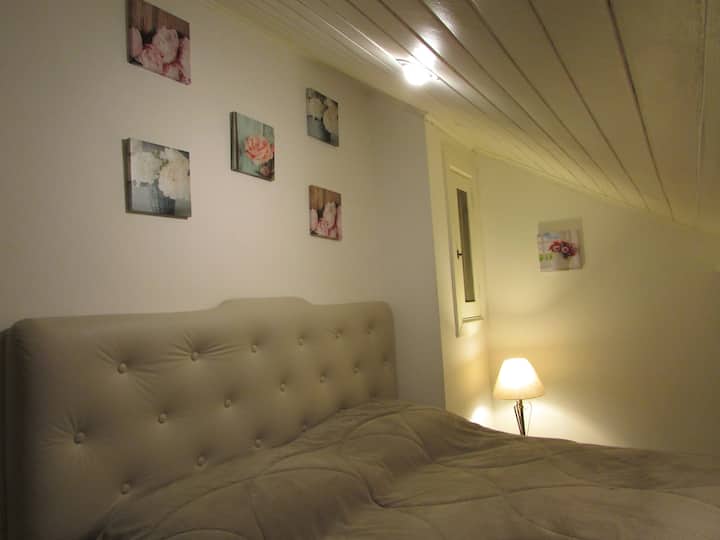 Bobrová posteľ, úplne nová, menšia ako menšia manželská posteľ, horná časť rady, v apartmáne. Tento apartmán má šikmý, prepadnutý strop.