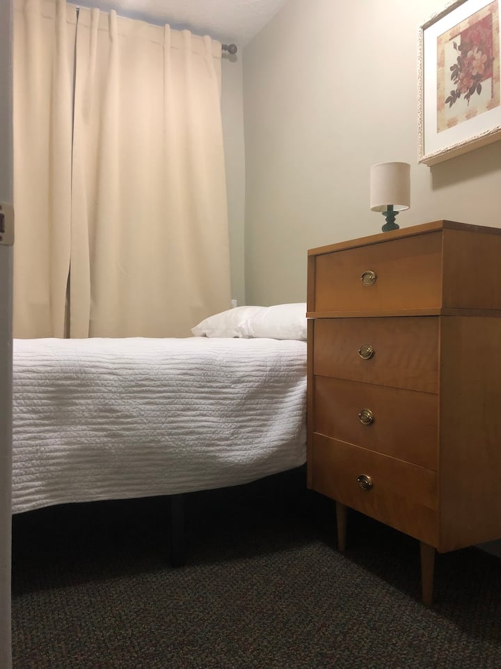 卧室配有双人床。  房间很小，但床下有充足的储物空间，大厅对面的卫生间里还有一个大衣柜。有一扇门，未显示。  约9 x 7英尺