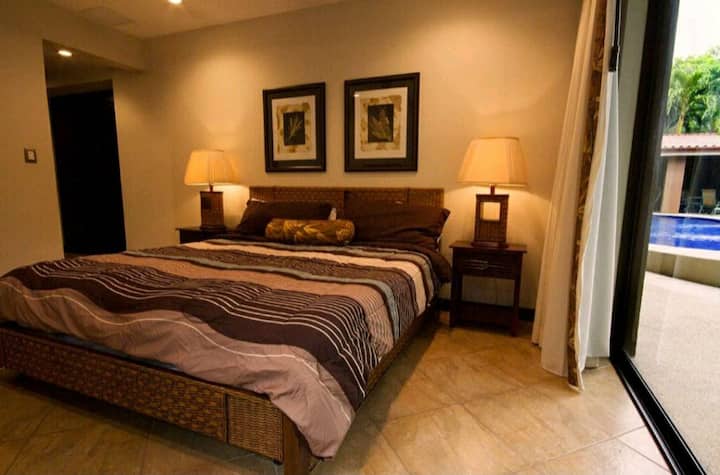 Dormitorio principal con cama king. Abre directamente al patio y a la piscina.