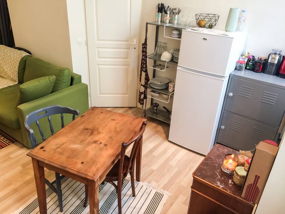 Dans la cuisine, avec tout ce qu'il faut pour cuisiner et s'installer à table.