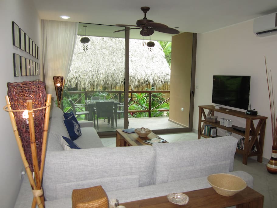 View from the kitchen of the living room, 50" Smart TV, and outside deck and pool area