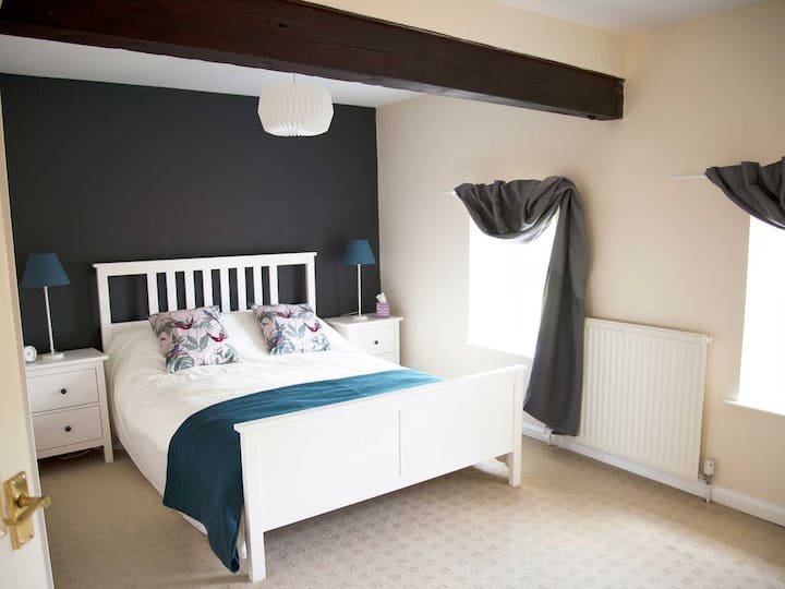 ห้องนอนใหญ่พร้อมเตียงคิงไซส์และคานแบบดั้งเดิม แถมห้องสุขาในตัว