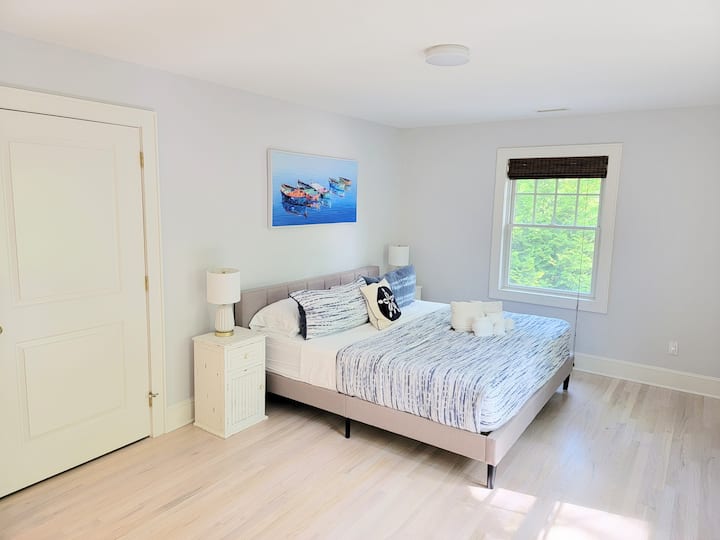 Une grande chambre avec lit King Size et salle de bain attenante.