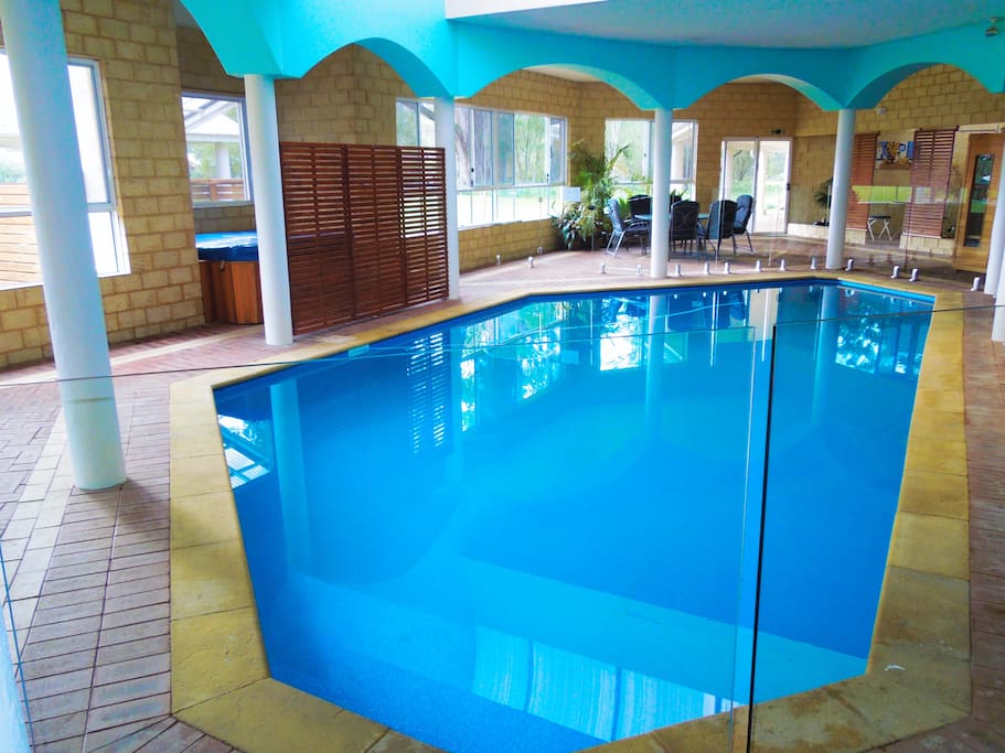 Spacious indoor entertainment area with pool, heated Jacuzzi, sauna, hooded BBQ, tables and chairs, plates, cutlery etc.