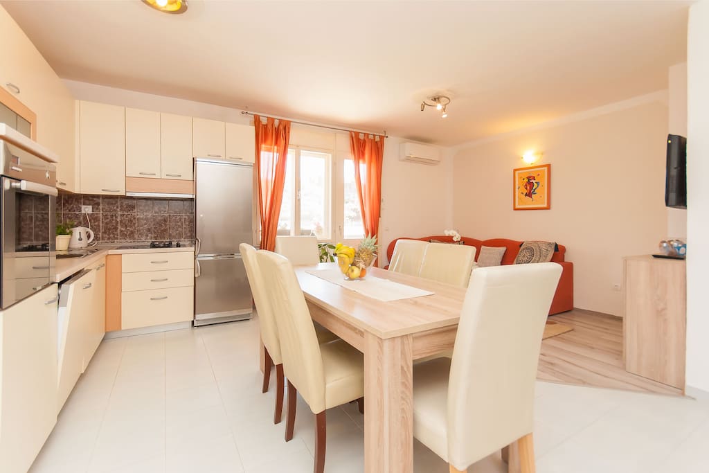Large living dining table and a large fully equipped kitchen including a dishwasher.