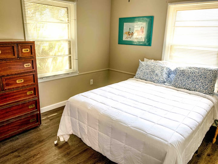 2nd bedroom with 32 inch tv, tall dresser, walk-in closet, and queen bed