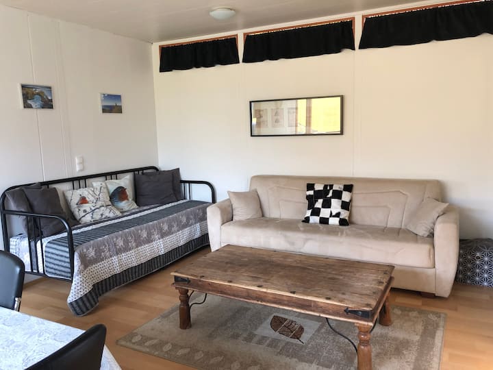 ที่พักสว่างสดใสและน่าอยู่พร้อมโซฟาที่สะดวกสบาย 2 ตัวและโต๊ะกาแฟไม้ซึ่งเป็นจุดที่สมบูรณ์แบบสำหรับการพักผ่อนหรือเพลิดเพลินไปด้วยกัน โซฟาตัวหนึ่งเปลี่ยนเป็นโซฟาเบดเพื่อเพิ่มพื้นที่นอนได้อย่างง่ายดาย