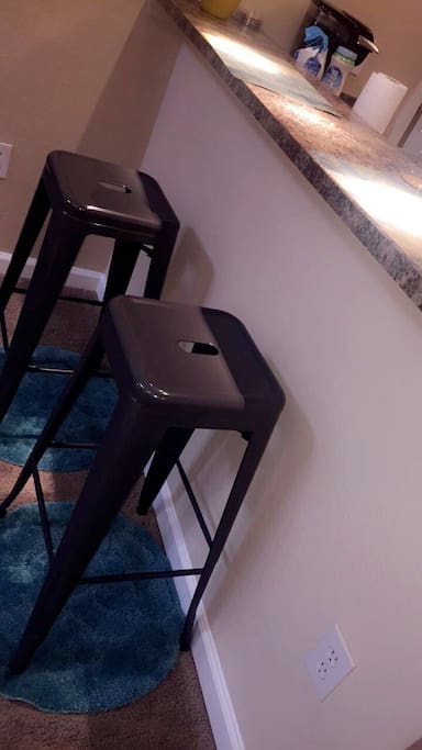 Open fully stocked kitchen with bar stools