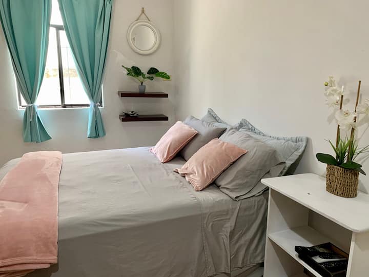 Spálňa veľkosti Queen na prízemí, televízor, šatník a kúpeľňa s toaletou.