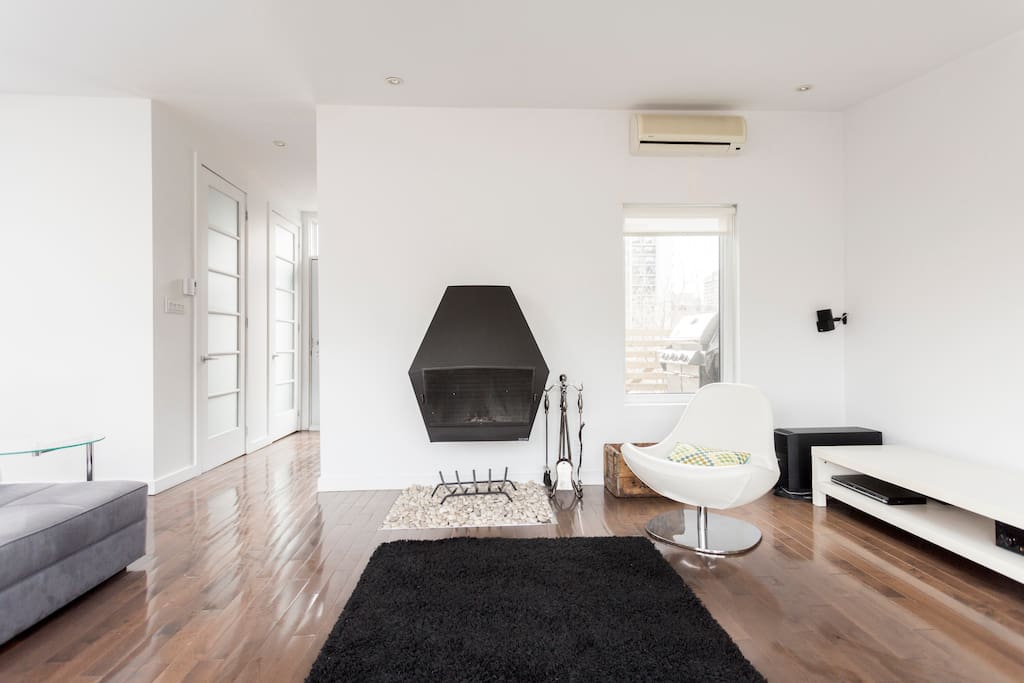 Living room, with 60 inch TV, on top floor (mezzanine), surrounded by windows and 2 large patios on either side of the living room.