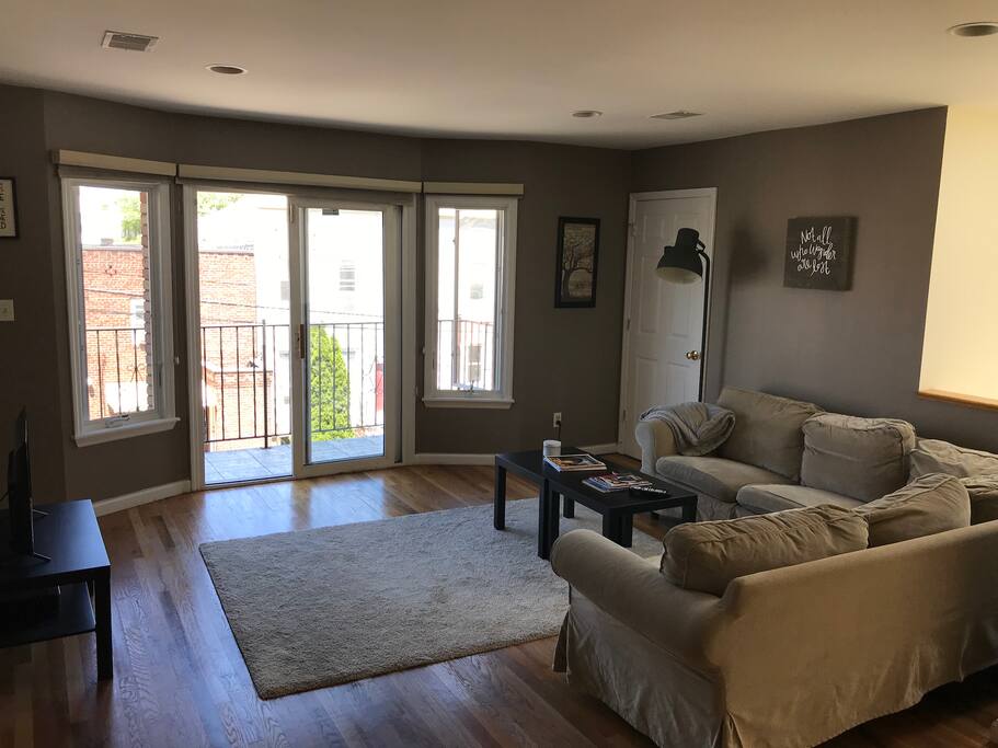The living room and balcony beyond on a sunny day.