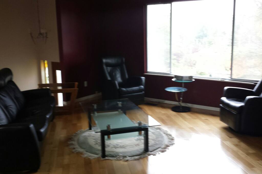 Inviting living room with oak floors and leather recliners.