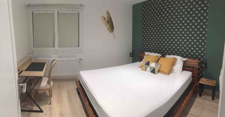 主卧配有一张长床、一个大衣橱、一张书桌和一张尿布更换台