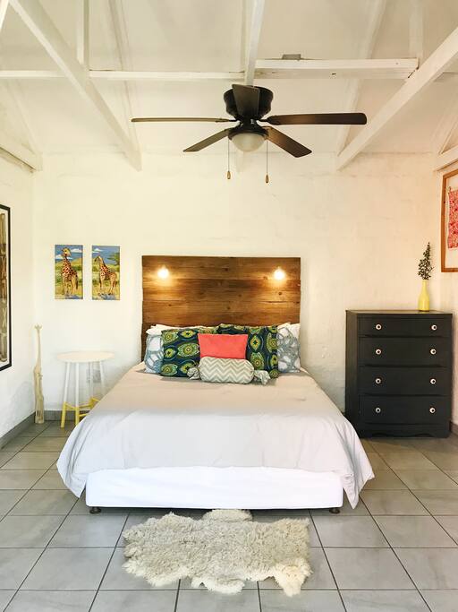 A queen bed with lights mounted on the headboard for reading