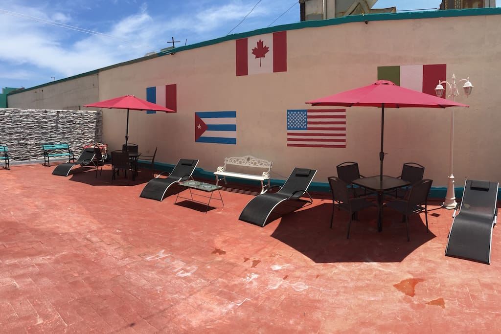 Huge private terrace for the guest with bar, deck chairs, tables, chairs and umbrellas