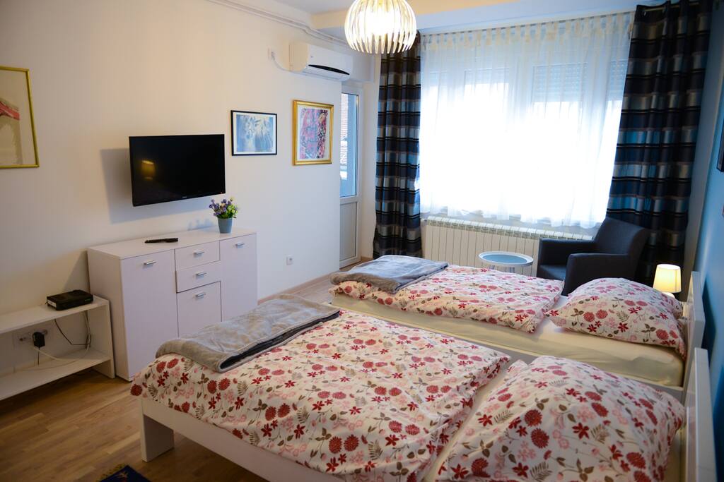 A cozy bedroom with 2 single beds, cable TV, balcony and AC
