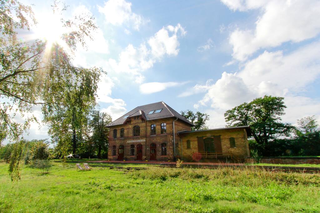 Große grüne Wiese vor dem Bahnhof.
